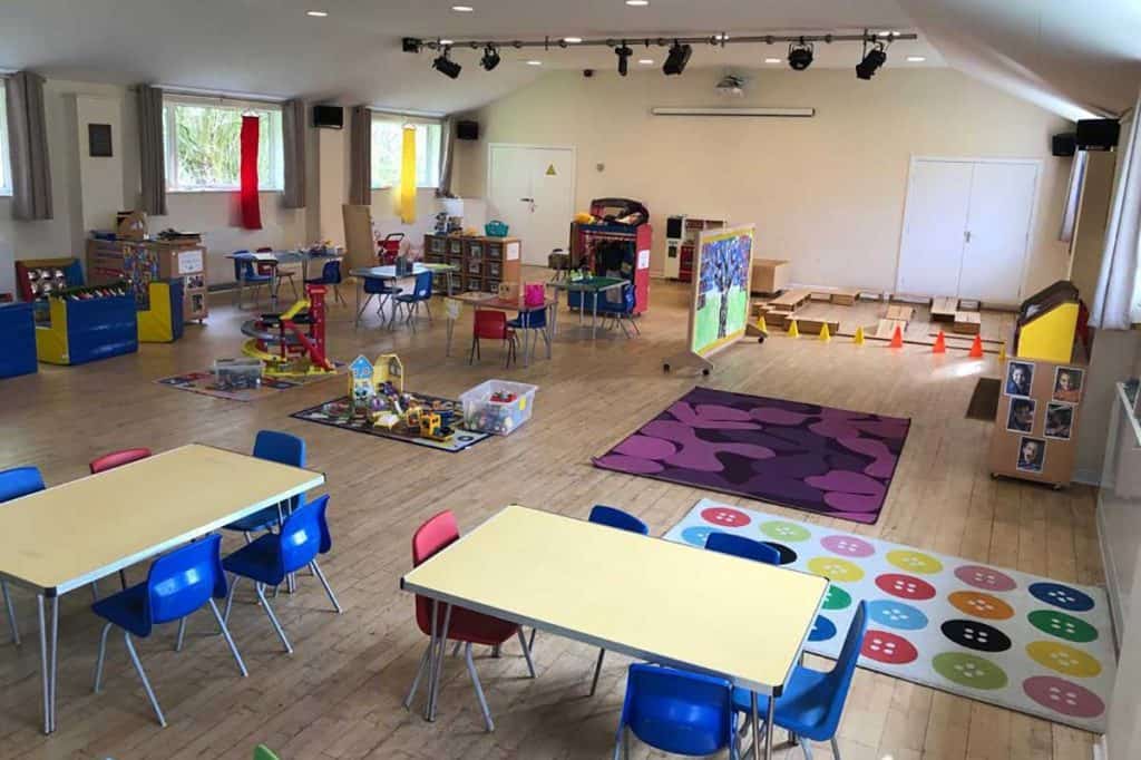 Preschool classroom with colorful furniture, toys, and play zones for early childhood education.